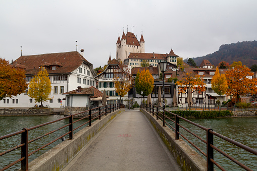 Thun, Switzerland: November 04, 2018: City view of Thun, with old and historical houses next to river Aare and the castle on the top of the city