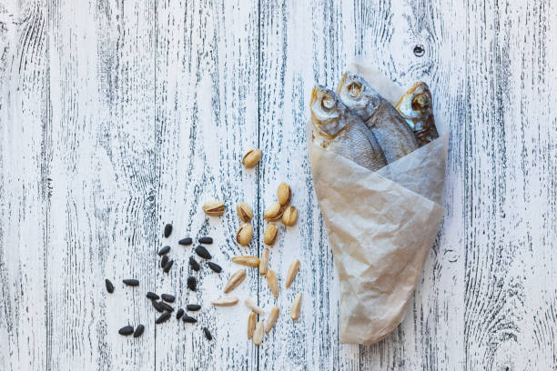 istock Three dried fish bream lie on a light wooden table. 1134073591