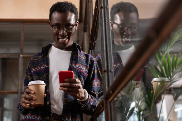 istock Man holding a coffee cup gripped with texting conversation 1134074123