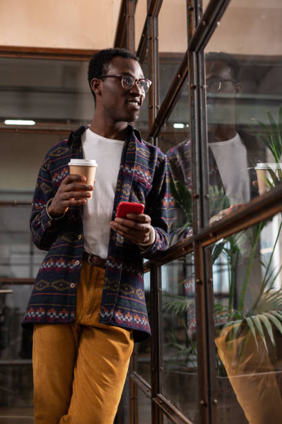 istock Man with coffee and a smartphone looking at the window 1134074125