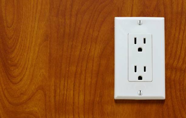 istock White power outlet on a wood grain surface. 1134079599