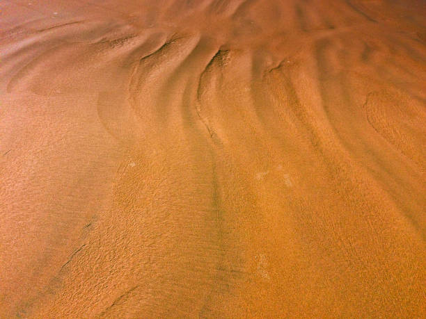 istock patterns from the waves and wind on the sand, sand of an unusual color 1134082900