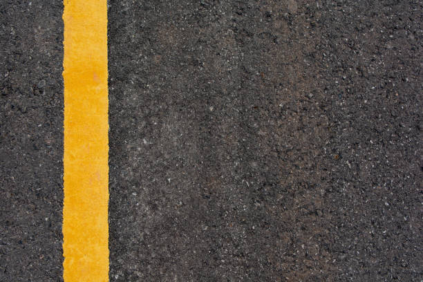 istock Yellow line on black asphalt road background with copy space 1134083204