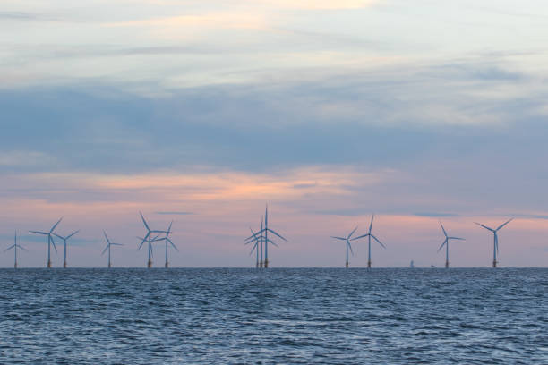 turbines éoliennes offshore sur l'horizon de la mer avec un beau ciel pastel - farm scenics landscape alternative energy photos et images de collection