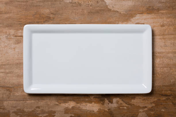 istock Empty white plate on brown wooden background 1134084074