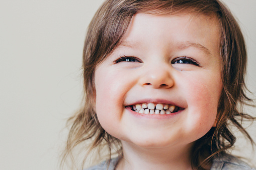 Adorable Blue Eyed Child Girl Laughing Close Up Portrait, Neutral Background