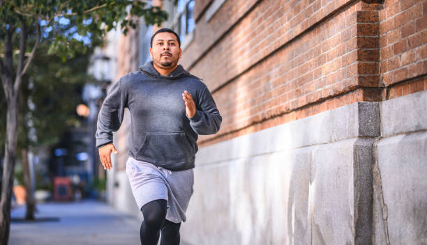 istock Determined athlete jogging on sidewalk in city 1134088280