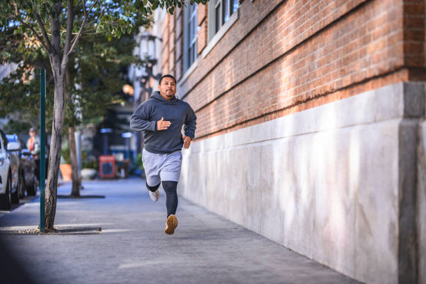 istock Determined athlete jogging on sidewalk in city 1134088282