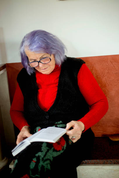 istock Elder woman reading a book at home and smiling 1134089899
