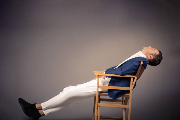 istock Businessman resting in chair against empty wall. 1134093279