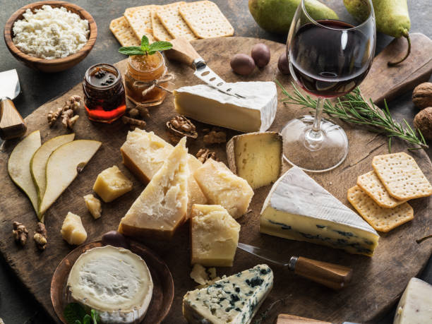 istock Cheese platter with different cheeses, fruits, nuts and wine on stone background. 1134093492