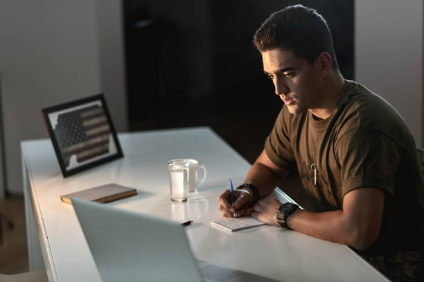 young sad us soldier writing letter to home. - depression sadness usa american flag imagens e fotografias de stock