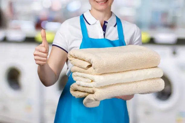 Photo of A laundry worker is holding clean towels.