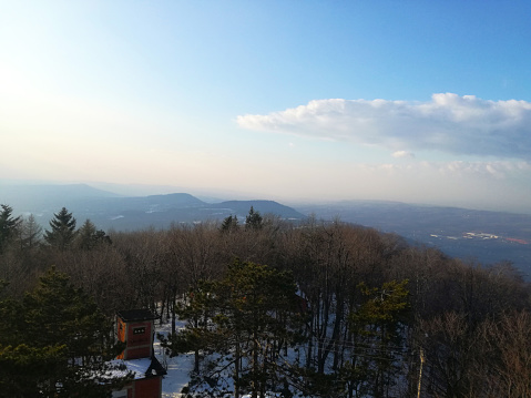 Panoramic view from the mountain with sunny blue sky and mountains and snow