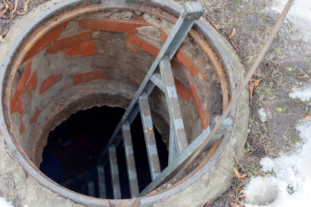 istock open sewer hatch. worker carries out work on the maintenance of communications. 1134102605