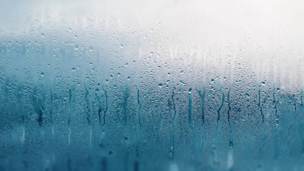 istock Dripping Condensation on the clear glass window. Water drops. Abstract background texture. Detail of moisture close up 1134106286