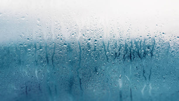 istock Dripping Condensation on the clear glass window. Water drops. Abstract background texture. Detail of moisture close up 1134106287