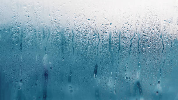 istock Dripping Condensation on the clear glass window. Water drops. Abstract background texture. Detail of moisture close up 1134106290