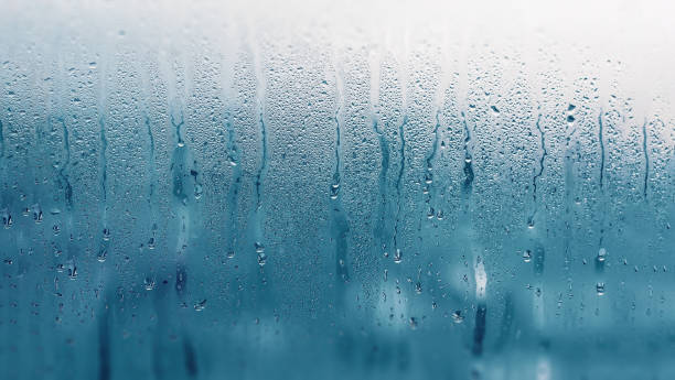 istock Dripping Condensation on the clear glass window. Water drops. Abstract background texture. Detail of moisture close up 1134106295