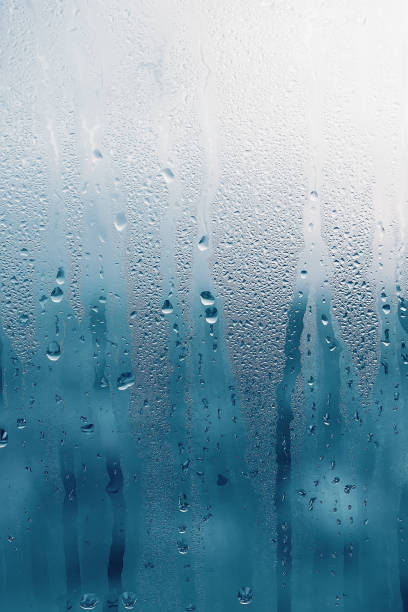 istock Dripping Condensation on the clear glass window. Water drops. Abstract background texture. Detail of moisture close up 1134106325