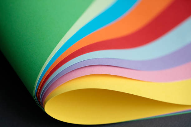 Abstract colored paper structure on blue, pink, and orange background.curled corners of papers.Papers corner curved and curled.