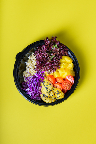 Hawaiian vegetarian poke bowl with tofu, pineapple and cole. Ready-to-eat, to go fast food. Healthy ingredients. Top view, flat lay.