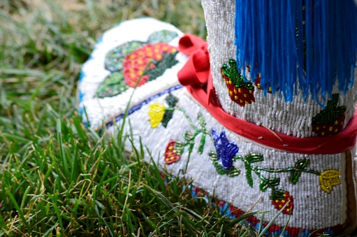 A single moccasin with beautiful handcrafted bead work.  These slippers or moccasins are worn during dance ceremonies and sacred events.  A pow-wow in Browning, Montana USA is where this pic was taken in the summer.