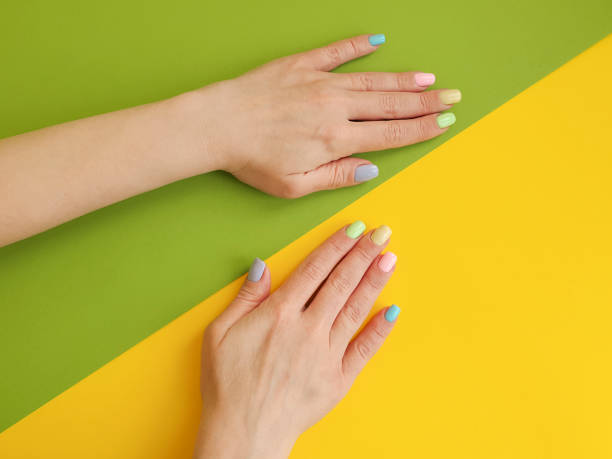 istock female hands manicure on color paper background 1134112053
