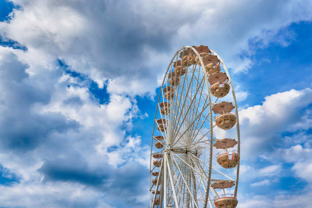 roda de ferris do parque justo e de divertimento. nuvens brancas no céu azul no fundo. - costume stage costume sunlight carnival - fotografias e filmes do acervo