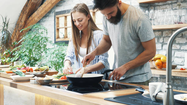 istock Young couple making dinner together at home 1134123208