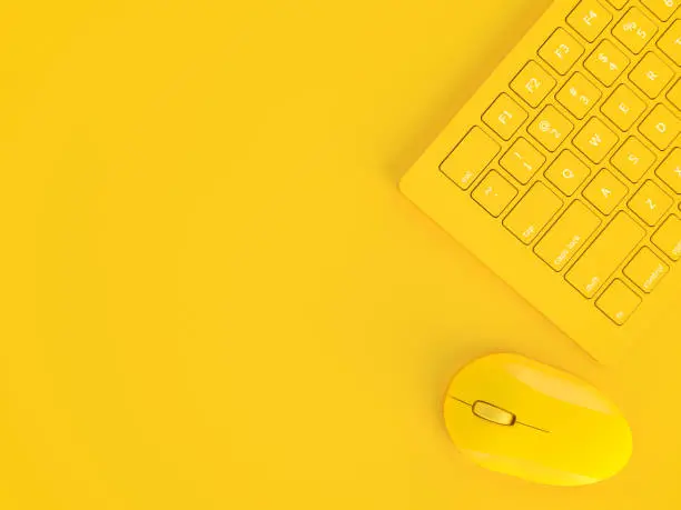 Photo of Minimal concept. Mouse beside keyboard yellow color
