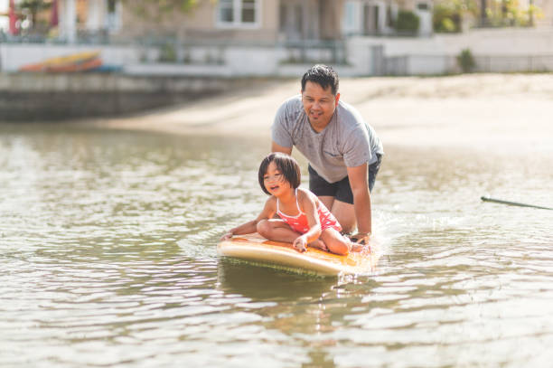 istock Filipino girl rides on a paddleboard with her dad 1134124901