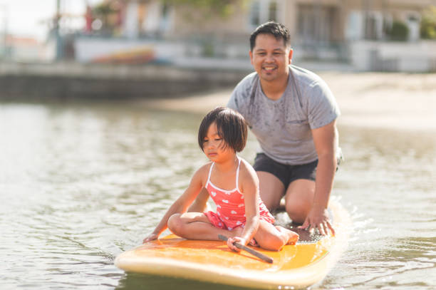 istock Filipino girl rides on a paddleboard with her dad 1134124909