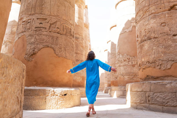 An Incredible Trip To Egypt Rear view of a female tourist enjoying a tour at the Great Temple of Amun in Karnak, Egypt. luxor thebes stock pictures, royalty-free photos & images