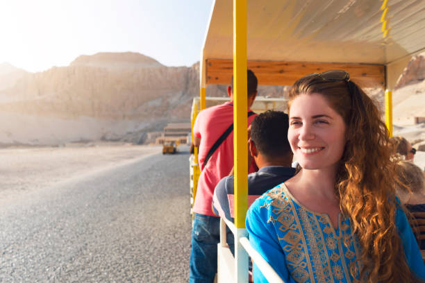 Taking A Tour Through Egypt Beautiful caucasian woman enjoying a tour to the Hatshepsut Temple in Egypt. luxor thebes stock pictures, royalty-free photos & images