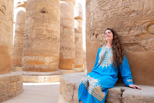 Beautiful caucasian woman enjoying a tour at the Great Temple of Amun in Karnak, Egypt.