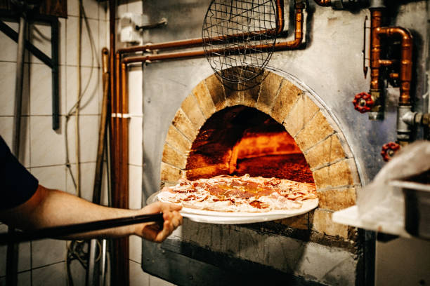 istock Man putting pizza in oven 1134128119