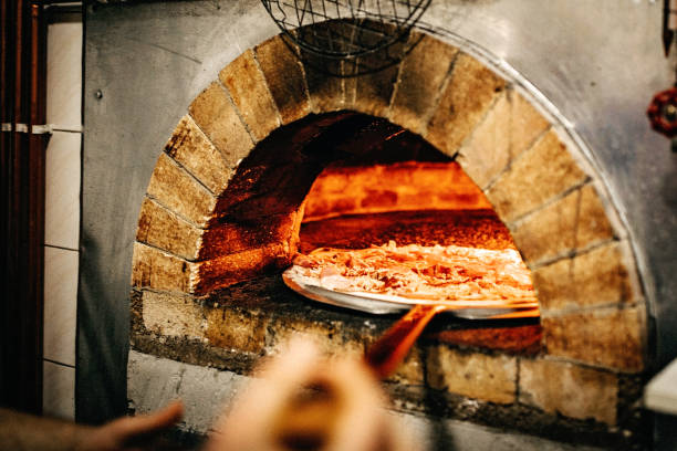 istock Man putting pizza in oven 1134128130