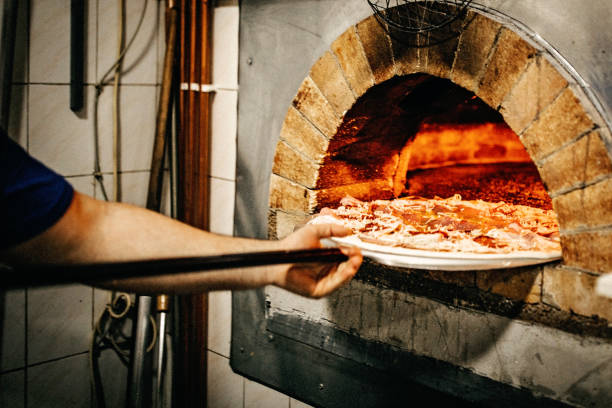 istock Man putting pizza in oven 1134129535