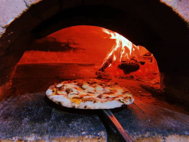 istock Man putting pizza in oven 1134130272