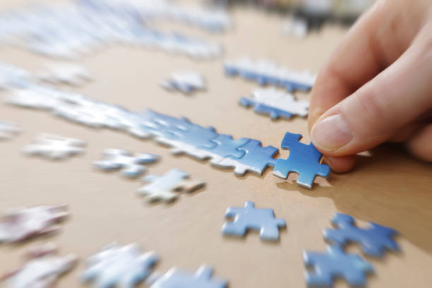 istock Hand placing puzzle pieces on a board 1134130279