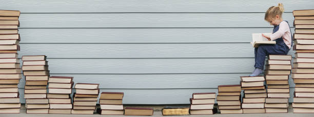 istock Young girl sits on stack of books 1134130517