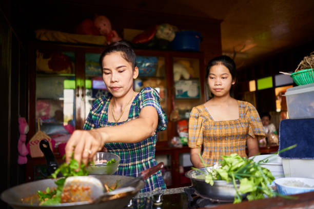 istock thai mother and daughter cooking together in rustic kitchen makign red curry 1134135279