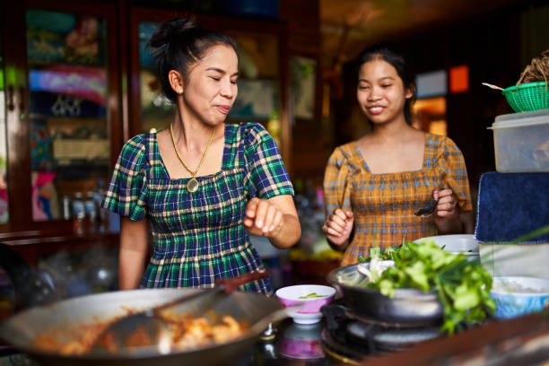istock thai mother and daughter cooking together in rustic kitchen making red curry 1134135281