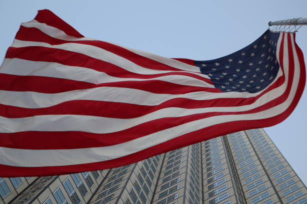 istock American flag fluttering in the wind against a skyscraper 1134139828