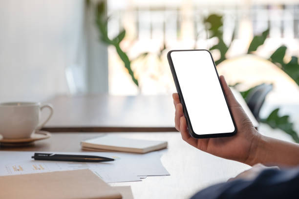 istock a woman holding and using mobile phone while working in office 1134140834
