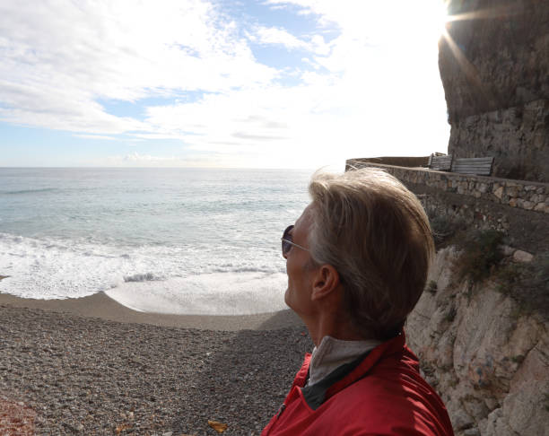 istock Mature man watches sunrise over beach 1134146632