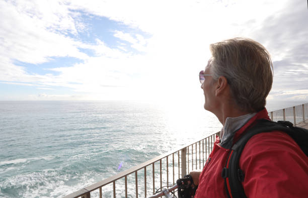 istock Mature man with bicycle watches sunrise over beach 1134146706