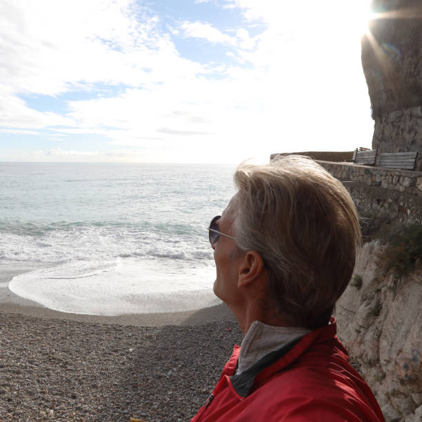 istock Mature man watches sunrise over beach 1134146722