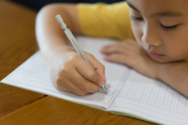 istock Little boy hand is writing homework at home.Education concept 1134152895